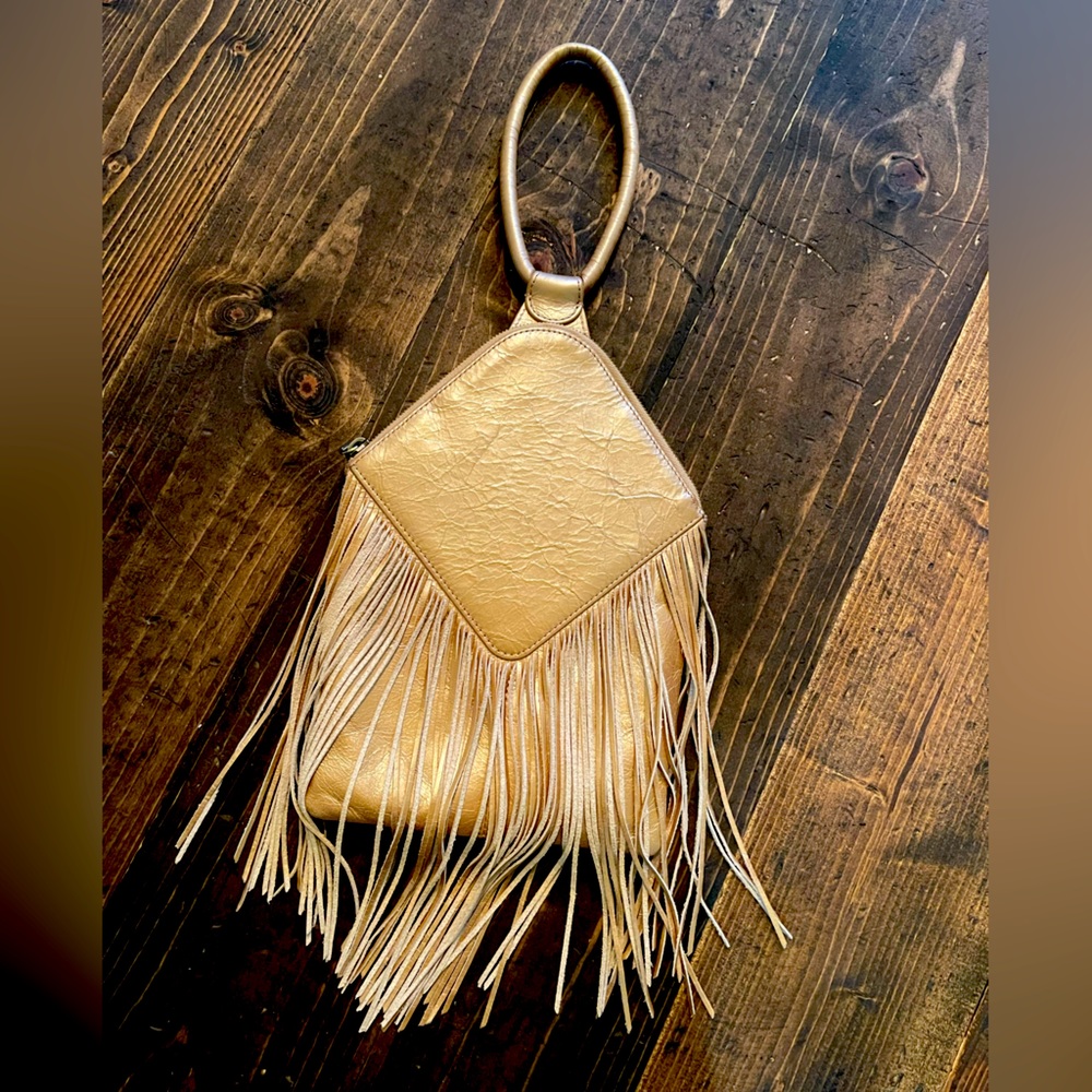 Hobo fringed metallic leather wristlet in gold.